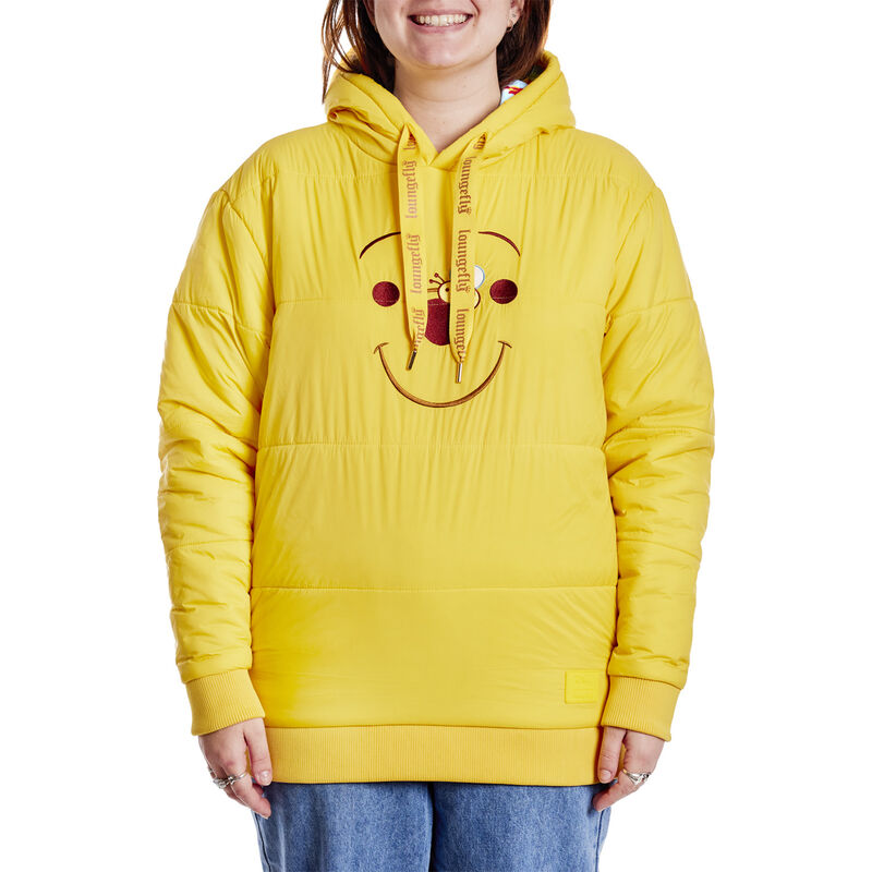 Model wearing the Loungefly Disney Winnie the Pooh Rainy Day Cosplay Puffer Unisex Hoodie, featuring quilted puffed material in yellow and Winnie the Pooh's face